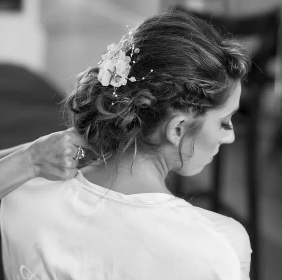 Bridal hair by Lee Elrom — braided chignon with floral pins, styled in black and white